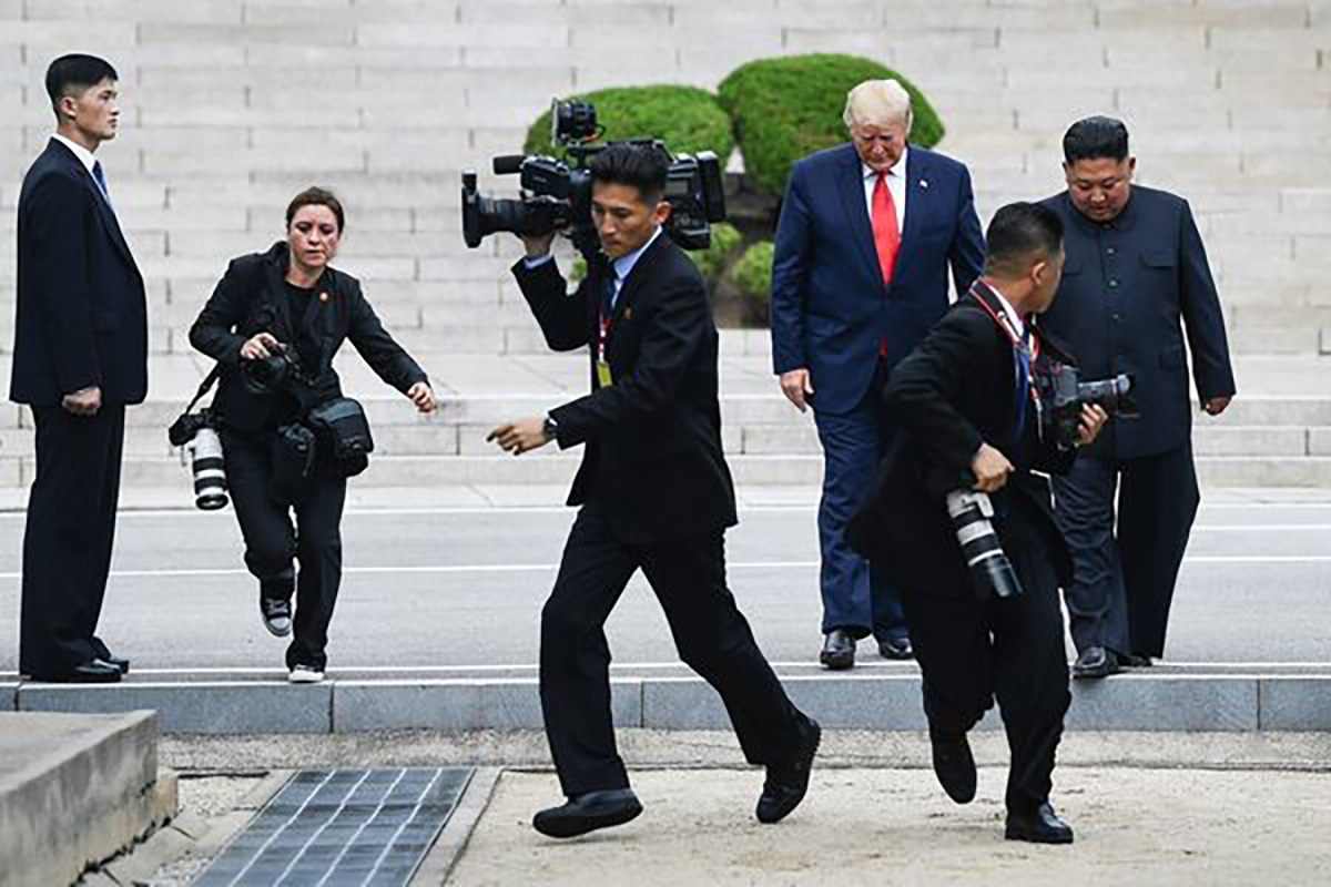 Photographers run as Kim and Trump cross south of the Military Demarcation