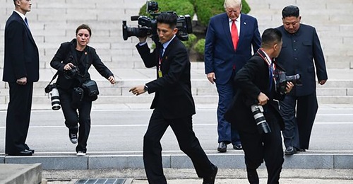Photographers run as Kim and Trump cross south of the Military Demarcation
