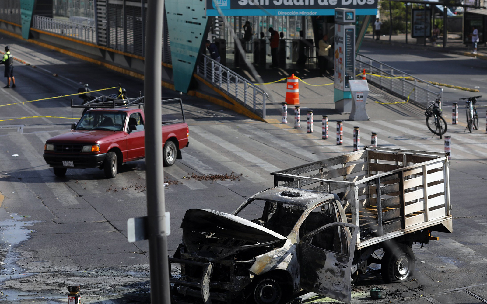 Torched vehicles and abandoned caltrops on a street in Guadalajara