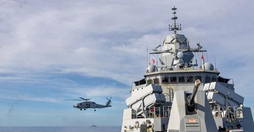 A Royal Australian Navy MH-60R Seahawk (N48-024) flies near HMAS 
        
         on 16 February 2026 during the vessel's second South China Sea transit as part of Australia's Regional Presence Deployment 2026-2.