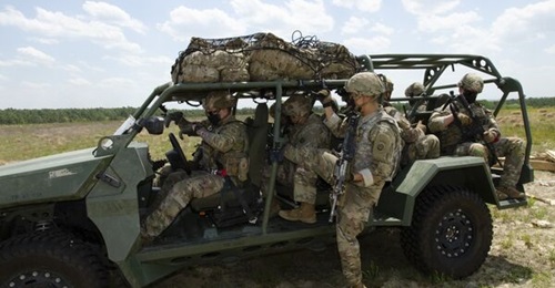 US Army infantry soldiers secure their rucks in the cargo netting on the roof of the ISV after it was airdropped at Fort Bragg during operational testing.