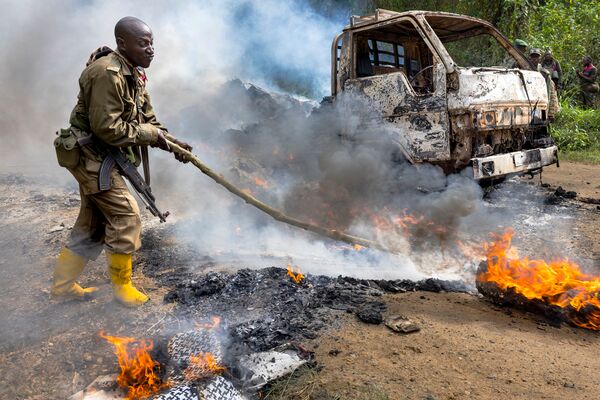 DRC soldiers inspect an ambush site where an hour previously ADF/Wilayat Wasat Afriqiyya insurgents had attacked two vehicles on the road between Beni and the Ugandan border town of Kasindi, on 9 April 2021 in Kilya, Rwenzori Sector, DRC. There have been multiple attacks across the province by the ADF, characterised by brutality and beheadings. (Brent Stirton/Getty Images)