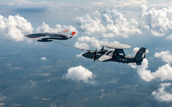 A company-owned Boeing MQ-25A Stingray unmanned tanker passes fuel to a US Navy-operated E-2D Advanced Hawkeye receiver aircraft during trials. (Boeing)