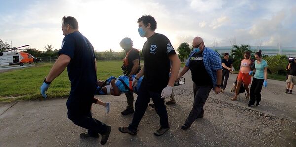 US Coast Guard Air Station Clearwater helicopter crew members assist a critically injured Haitian citizen on 18 August. (US Coast Guard)