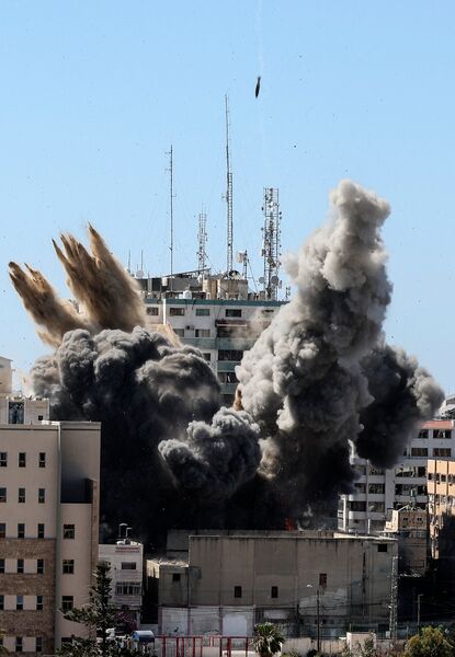 A munition hits the Al-Jalaa Tower in the Gaza Strip as a second guided bomb descends towards the building on 15 May. (Mahmud Hams / AFP via Getty Images)