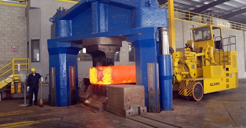 A forging press shapes a heated block of titanium.