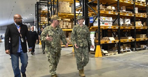 US Navy officers tour a Defense Logistics Agency warehouse facility at Naval Air Station Sigonella, Sicily, Italy.