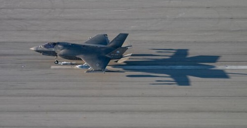 An F-35B touches down, likely at NAS Patuxent River, with an LRASM on the left wing.