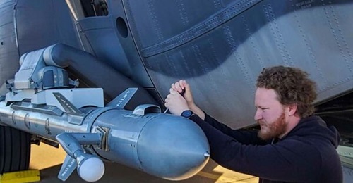 An engineer works on the ALQ-167 Angry Kitten pod attached to a C-130.