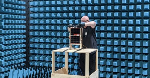 A DSTG engineer attaches a radio frequency cable to the engineering model of the Buccaneer Main Mission nanosatellite.
