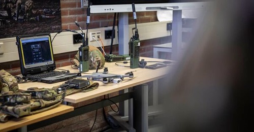 An L3Harris AN/PRC-171 team radio (immediately to right of laptop) and an AN/PRC-163 multichannel handheld radio (right) during a presentation of radio systems for the Netherlands MTBB project, held on 25 January 2024 in Amersfoort, the Netherlands.