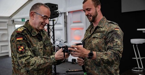 General Carsten Breuer being shown a small UAV at a conference on UAV technology.