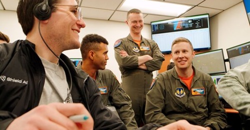 A Shield AI autonomy engineer conducts a flight debrief with USAF aviators as part of DARPA's Air Combat Evolution programme.
