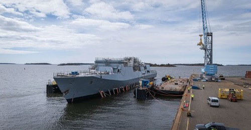 The first Pohjanmaa-class corvette is lowered into the water using a submersible barge.