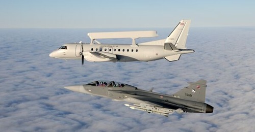 An RTAF Saab Gripen D flies alongside an RTAF Saab 340 airborne early warning aircraft.