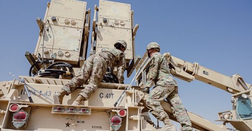 Personnel from the US Army's 31st Air Defense Artillery Brigade load PAC-2 missiles onto a Patriot launcher at Al-Udeid Air Base in February 2021.