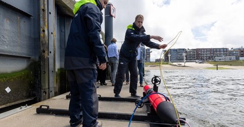 A Lobster Robotics AUV is prepared for deployment in Scheveningen harbour using a floating pontoon.