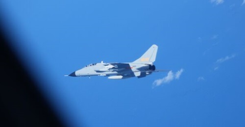 A Chinese Xi'an JH-7 supersonic, twin-seat combat aircraft flies close to a Japanese YS-11EB surveillance aircraft in July 2025.