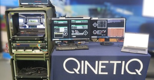 The QinetiQ T&S deployable digital experimentation test rig shown at DSET 2025. The replica GVA hardware is on the left with the synthetic vehicle crew displays - gunner, commander, and driver - on the right.