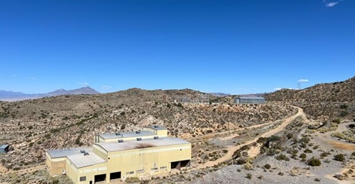 A view of 1980s mining infrastructure at Guardian Metal Resources' Tempiute tungsten project in southern Nevada. A mill is in the foreground and a substation in the background to the right.