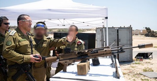 Lt Gen Eyal Zamir inspects a SIG Sauer machine gun on 23 July.