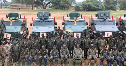 The trainees with MCAV-20 vehicles in the background.