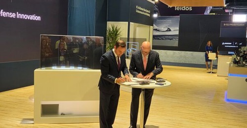 Mike Gallagher (left) and Steve Parker (right) sign ceremonial documents formalising the partnership between their companies on 23 September during AFA's Air, Space, and Cyber Conference 2025.
