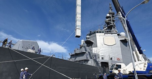 The JMSDF Kongo-class destroyer JS 
        
        being loaded with a mock Tomahawk round prior to its departure for the US where it will be modified for the weapon.