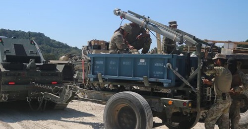US Army 36th Engineer Brigade soldiers perform checks on a trailer carrying an M58 MICLIC.