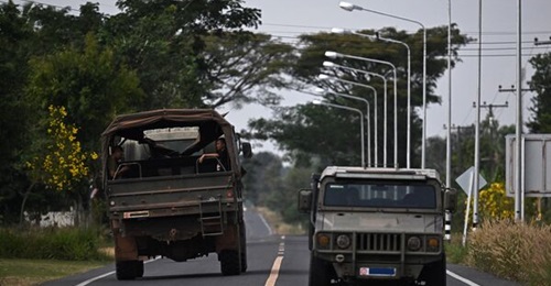Thai military vehicles are pictured on a road in the Thai border province of Surin on 11 December amid continuing clashes along the Thai-Cambodia border.