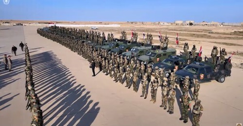 Soldiers from the 65th Special Forces Brigade formed up on the taxiway on the northwest side of Ain al-Asad Air Base, an area previously used by the US-led coalition.