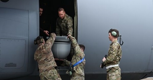 US Air Force personnel load up a roll-on, roll-off BLOS Tactical Removeable Airborne Satellite Communications capability into a C-130 combat airlifter.