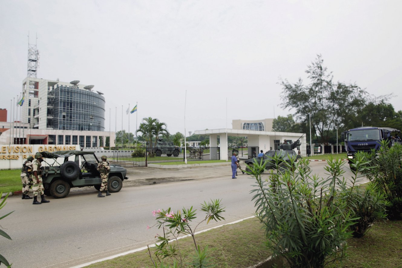 Soldiers and vehicles – including an Aravis in the background – from the Republican Guard are seen outside the Radio Télévision Gabonaise building in Libreville on 7 January. (Steve Jordan/AFP/Getty Images)