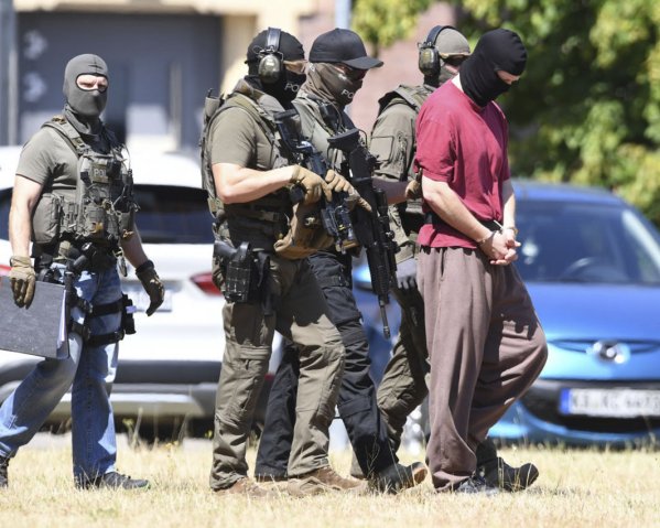 Police escort the main suspect in the killing of German politician Walter Lübcke back into custody following a hearing on 2 July. (Uli Deck/AFP/Getty Images)