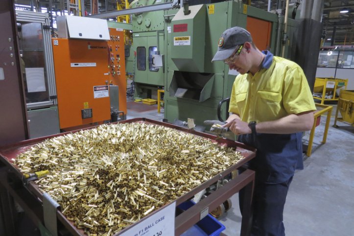 Patrick Warner, an employee at Thales Australia, examines cartridge cases for 5.56 mm ammunition, part way through the manufacturing process at the Benalla, Victoria, production line. (Australian Department of Defence)