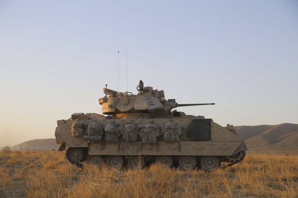 An M2A2 Bradley observes the terrain for enemy elements during training at Fort Irwin, California, in May 2018. The US Army has tasked BAE Systems with refitting two A2 Bradley vehicles with hybrid electric drives. (US Army/PFC Antoine Rolle)