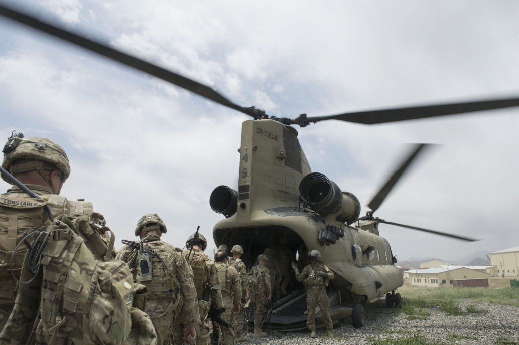 US soldiers enter a US Army CH-47 Chinook helicopter at an Afghan National Army combat outpost in Afghanistan on 23 June 2015. US President Donald Trump has announced plans to further cut the number of US troops in Afghanistan to between 4,000 and 5,000 by 3 November.  (USAF)