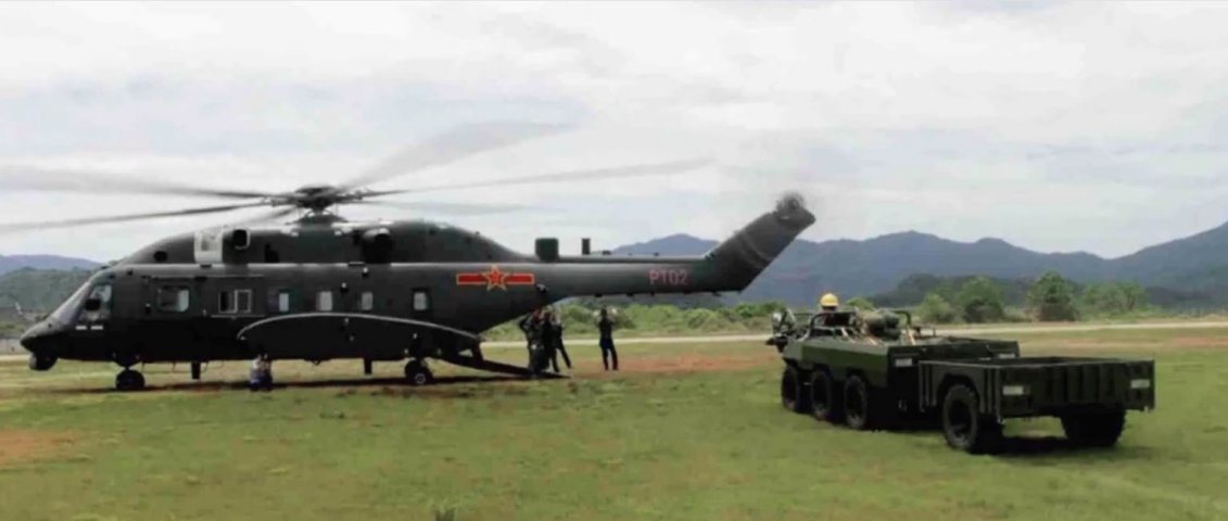 A screengrab from CCTV footage showing the wide-body variant of the CAIG Z-8G medium-lift helicopter shortly before undertaking load-carrying trials with the all-terrain vehicle seen next to it. (Via cctv.com)