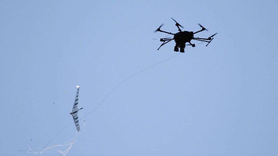 Fortem Technologies’ DroneHunter UAS (right) uses its NetGun net attached to a tether to capture an enemy UAS. (Fortem Technologies)