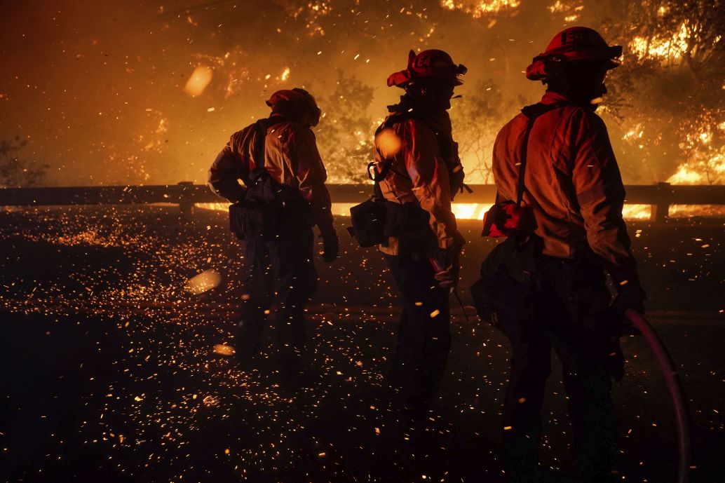 Firefighters tackle a fire in vegetation in Silverado, California, on 3 December 2020. Climate change is increasing in prevalence in national security and intelligence assessments.  (Kent Nishimura/Los Angeles Times via Getty Images)